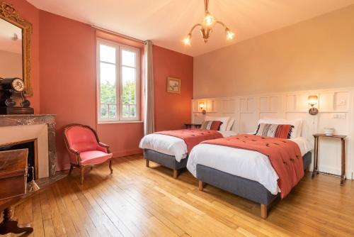 two beds in a room with red walls and a fireplace at Edouard & Louise - Chambres d'hôtes in Limoges