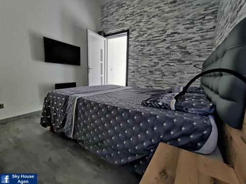 a bedroom with a bed and a brick wall at Spa Privatif Terrasse sans vis à vis ,,,Sky House Agen,,, in Agen