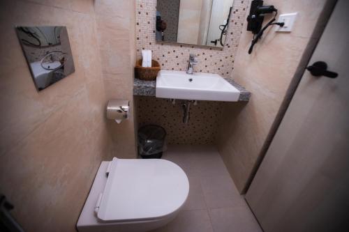 a bathroom with a white toilet and a sink at Vastu Boutique Hotel in Kathmandu