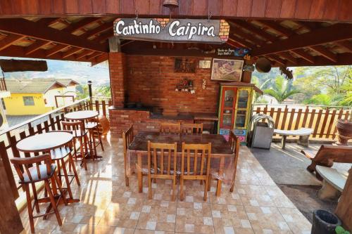 a restaurant with tables and chairs on a patio at Pousada Pé da Serra in Lindóia