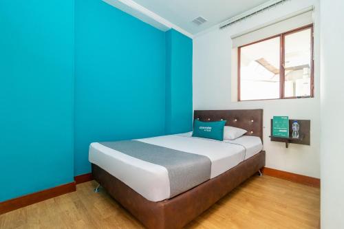 a bed in a room with blue walls and a window at Ayenda Palermo Plaza in Bogotá