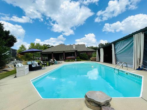 basen z niebieską wodą przed domem w obiekcie Lake Hamilton Pool House with Cabana and NEW hot tub! w mieście Hot Springs