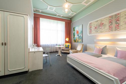 Schlafzimmer mit einem Bett, einem Schreibtisch und einem Fenster in der Unterkunft W22 Hotel am Kurfürstendamm in Berlin