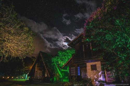 a house with green lights on it at night at Pousada Recanto das Aves in Iguape