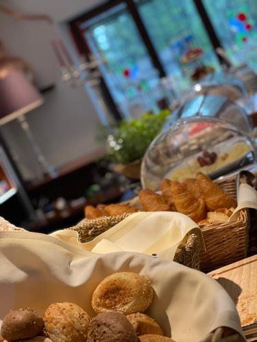 a table topped with baskets of bread and pastries at Trompeterschlössle Hotel & Residence in Tägerwilen