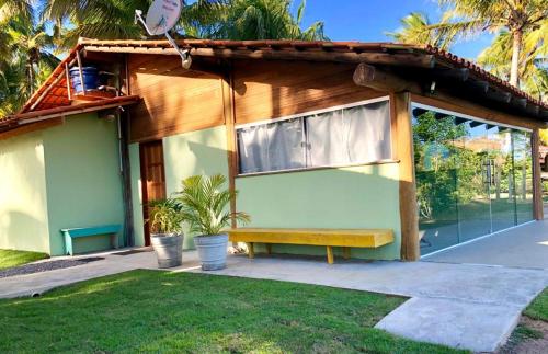 a house with a bench in front of it at Casa Verde, beira da água com 2 suítes - Mar Doce! in Caravellas