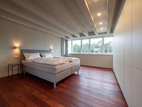 een slaapkamer met een bed en een groot raam bij FREIRAUM PRORA - LOFT 5.1 in Binz