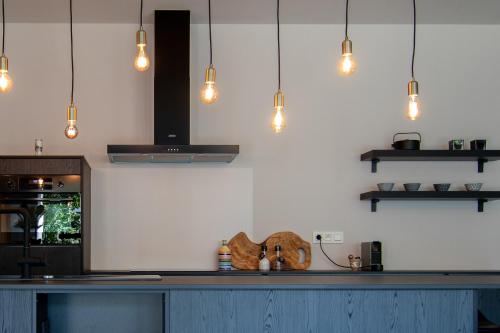 a kitchen with a counter with lights on it at Boulevard Botanie city apartment with parking in Hasselt