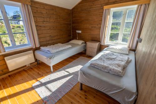 2 Betten in einem Zimmer mit 2 Fenstern in der Unterkunft Å-Hamna Rorbuer in Å