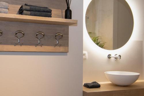 a bathroom with a sink and a mirror at Boulevard Botanie city apartment with parking in Hasselt