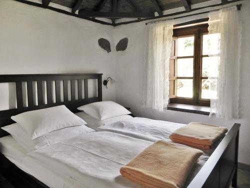 a bedroom with a bed with white sheets and a window at La Casita de la Vega in Icod de los Vinos