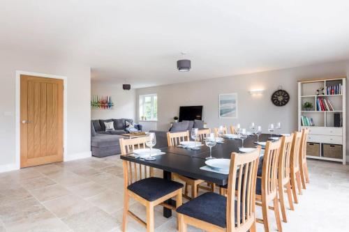 a dining room and living room with a table and chairs at Green Ridge - detached seaside home in Chichester