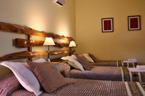 a hotel room with two beds and two lamps at Portal de La Cumbre in La Cumbre