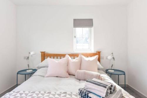 a bedroom with a bed with two blue tables at The Little House, boutique home near the sea in Chichester