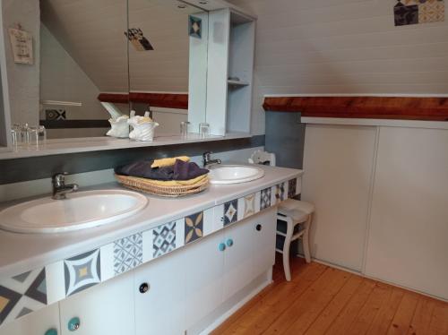a bathroom with two sinks and a mirror at 3 chambres spacieuses du grès rouge in Beauval