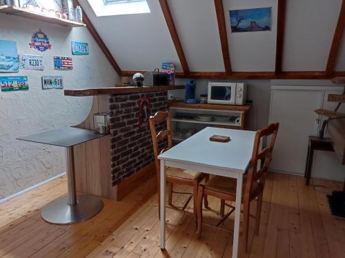 une cuisine avec une table et des chaises dans une pièce dans l'établissement 3 chambres spacieuses du grès rouge, à Beauval