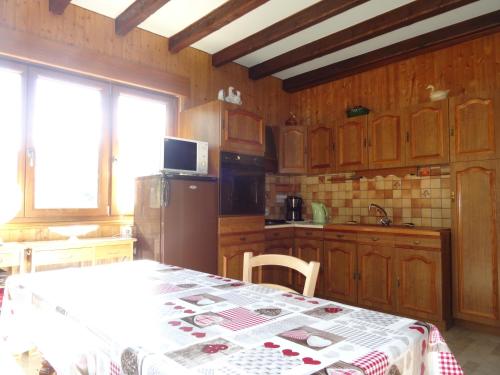 une cuisine avec une table recouverte d'une nappe dans l'établissement Gîte à l'Orée du Bois, à Steige