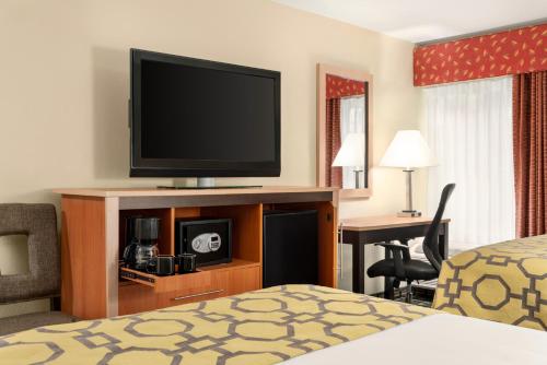 a hotel room with a bed and a flat screen tv at Baymont by Wyndham North Dartmouth Fall River in North Dartmouth