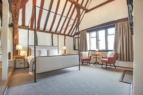 a bedroom with a bed and a desk and chairs at Kings Arms Hotel in Amersham