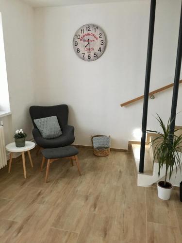 a room with a chair and a clock on the wall at Ubytování Na Jarošce in Hodonín