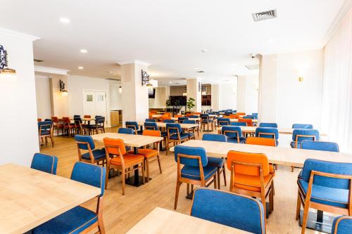 une salle de classe vide avec des tables et des chaises dans une cafétéria dans l'établissement Dona Amélia Hotel by RIDAN Hotels, à Fátima