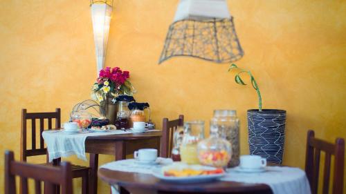 a dining room with two tables and chairs with flowers at All Blue in Jericoacoara