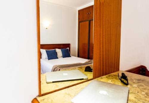 a hotel room with a bed and a mirror at Dona Amélia Hotel by RIDAN Hotels in Fátima