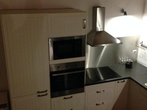 a kitchen with a stove and a microwave at Adega Do Mirante in São Roque do Pico