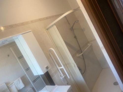 uma casa de banho com um chuveiro e uma porta de vidro em House Dongo 2021 em Dongo