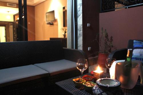 a living room with a couch and a table with wine glasses at Collier De La Colombe in Meknès