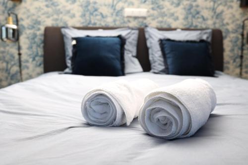 a bed with two rolled towels on it at Heeren aan de Haven in Streefkerk