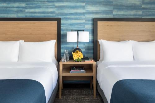 a hotel room with two beds and a table with a lamp at Hotel Caza Fisherman's Wharf in San Francisco