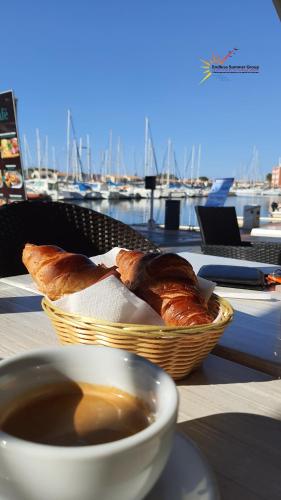 - un bol de café et un panier de pain sur une table dans l'établissement Studio 16 Le Cap d'Agde avec Parking privé proche du centre, au Cap d'Agde