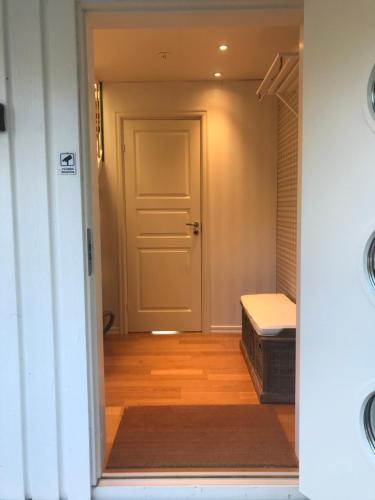 a hallway with a door and a bed in a room at Videvägen 20 Strömstad in Strömstad