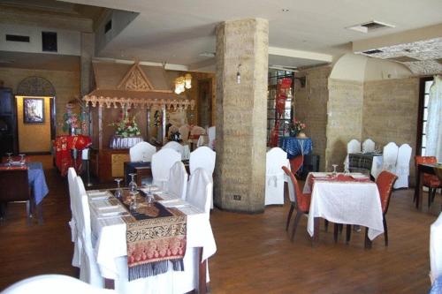 a dining room with white tables and white chairs at Nile Zamalek Hotel in Cairo