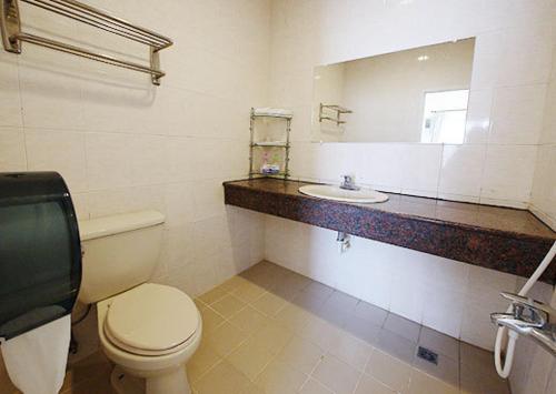 een badkamer met een toilet, een wastafel en een spiegel bij Formost Hotel in Kenting