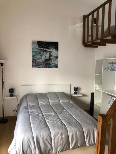 un lit dans une chambre avec un tableau sur le mur dans l'établissement Résidence chêne percé Appartement au RDC 51 m2, à Dieppe