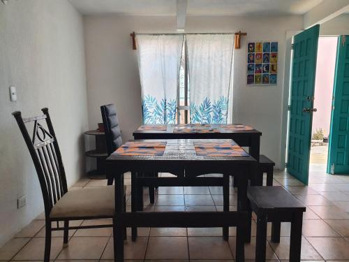 a dining room with a table and chairs and a window at Nómadas Hostel in La Paz