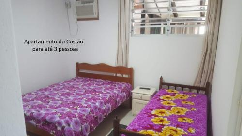 um quarto com uma cama roxa e uma janela em De frente para o Mar da Gamboa em Garopaba