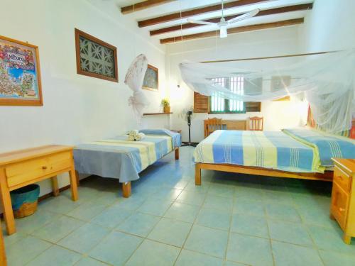 1 Schlafzimmer mit 2 Betten, einem Tisch und einem Schreibtisch in der Unterkunft Villa Escondida in Zipolite