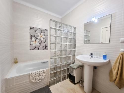 a white bathroom with a sink and a bath tub and a sink at Beachfront Villa Torrox Costa in Torrox Costa