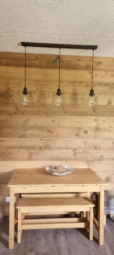 a table with three lights on a wooden wall at Luxury Central Apartment MONTCHAVIN in Bellentre