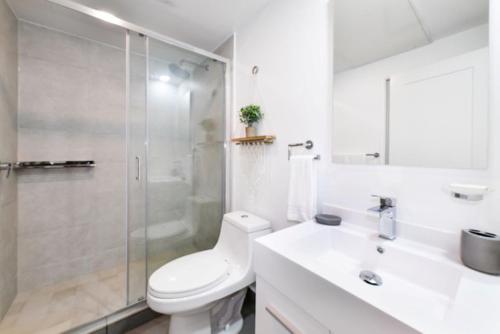 a bathroom with a toilet and a shower and a sink at Stylish luxury condo, central location, ocean view, pool, gym in Oranjestad