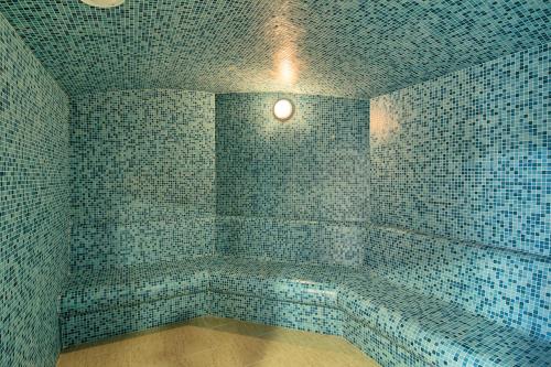 梅迪亚什Mercure Medias Binderbubi Hotel And Spa的浴室拥有蓝色瓷砖墙壁和灯具