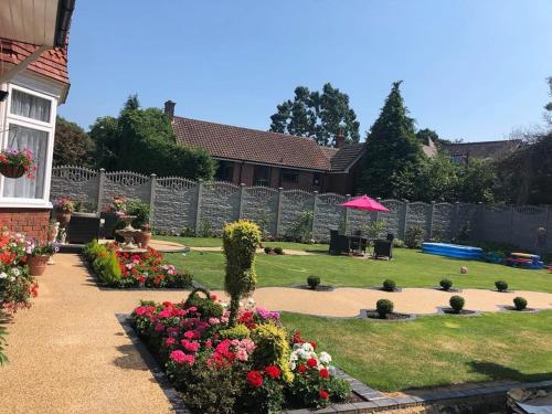 a garden with flowers and an umbrella in a yard at ElMurrs in Bournemouth