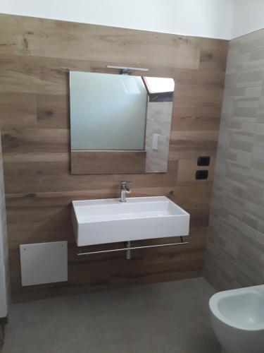 La salle de bains est pourvue d'un lavabo, d'un miroir et de toilettes. dans l'établissement Angelica, à Lecce