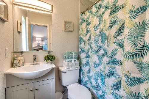 W łazience znajduje się umywalka, toaleta i lustro. w obiekcie Cortez Gardens Cottage 15, Renovated and close to Beach, 3-Bed, 2-Bath 10 People w mieście Bradenton