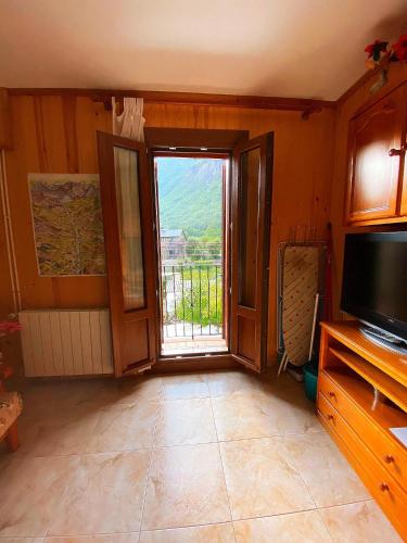ein Wohnzimmer mit einer Tür, die auf einen Balkon führt in der Unterkunft Casa Joan 2Pax in Barruera