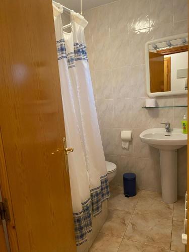 y baño con cortina de ducha y lavamanos. en Casa Joan 2Pax en Barruera