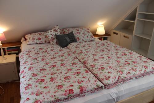a bed with a floral comforter and pillows on it at gemütliches Gästezimmer in Ostseenähe in Stubbendorf